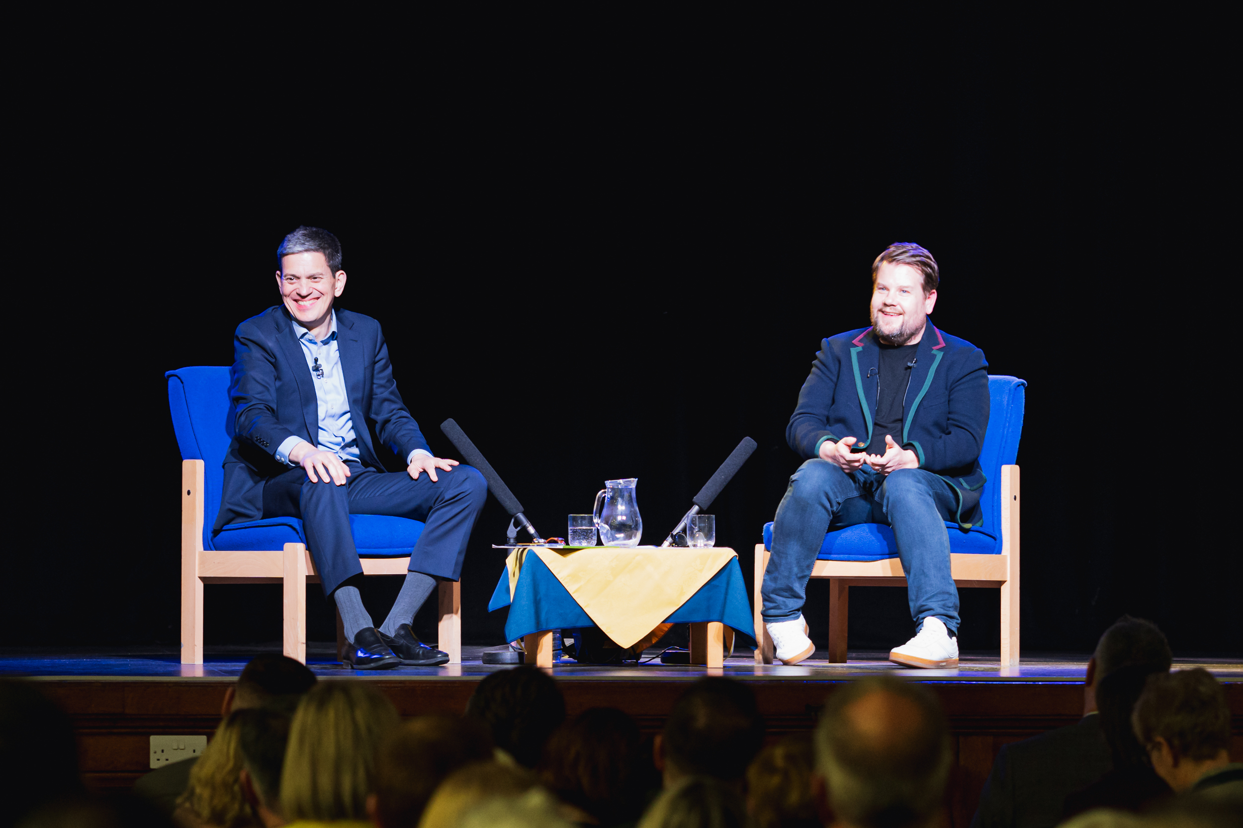 James Corden and David Miliband on stage at the event