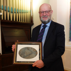 Prof. Adrian Simpson with the original 100th anniversary plaque.