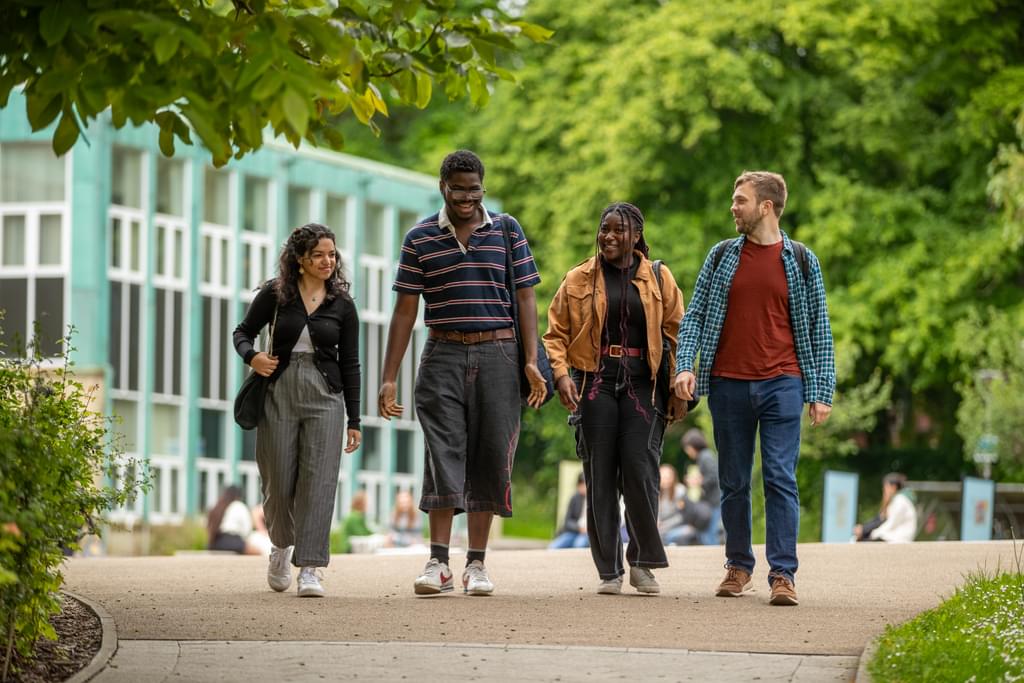 four students walking talking to each other