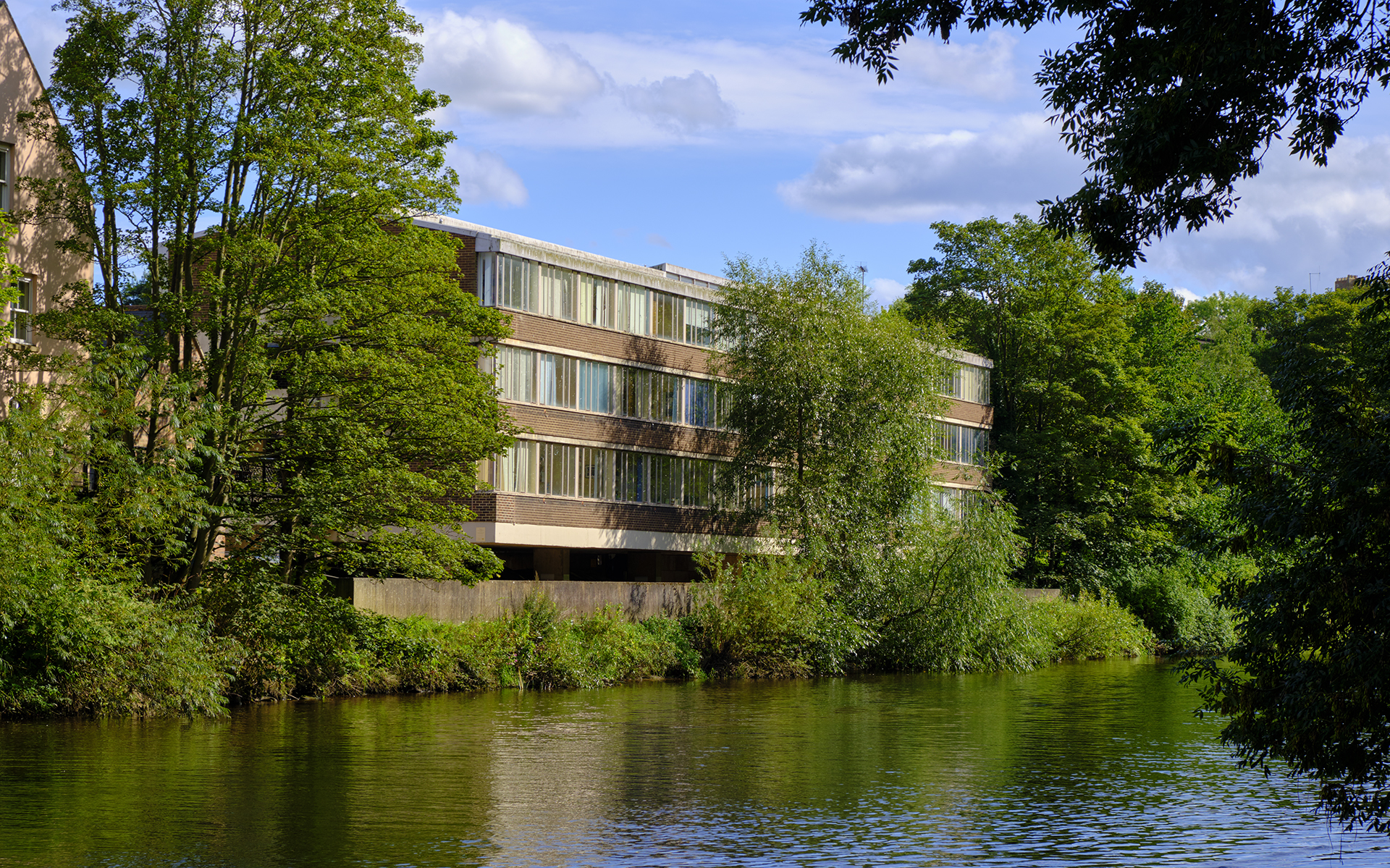 A view of the Elvet Riverside building with trees and the river Wear in front