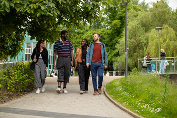 Four students walking in front of the geography building