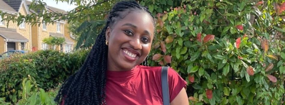 Student smiling in front of a tree