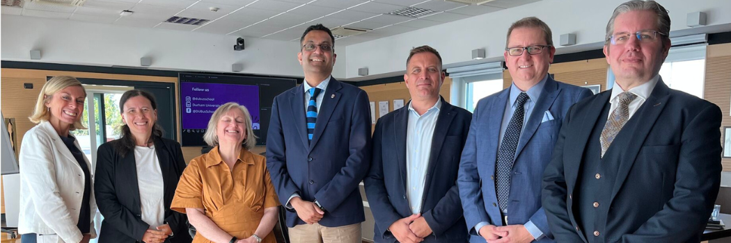 Attendees to the partnership announcement standing in a foyer smiling to the camera