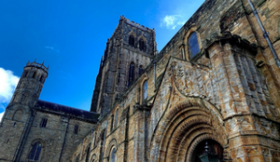 Durham Cathedral from below with a blue sky in background