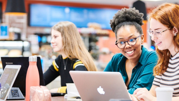 Smiling students using a laptop