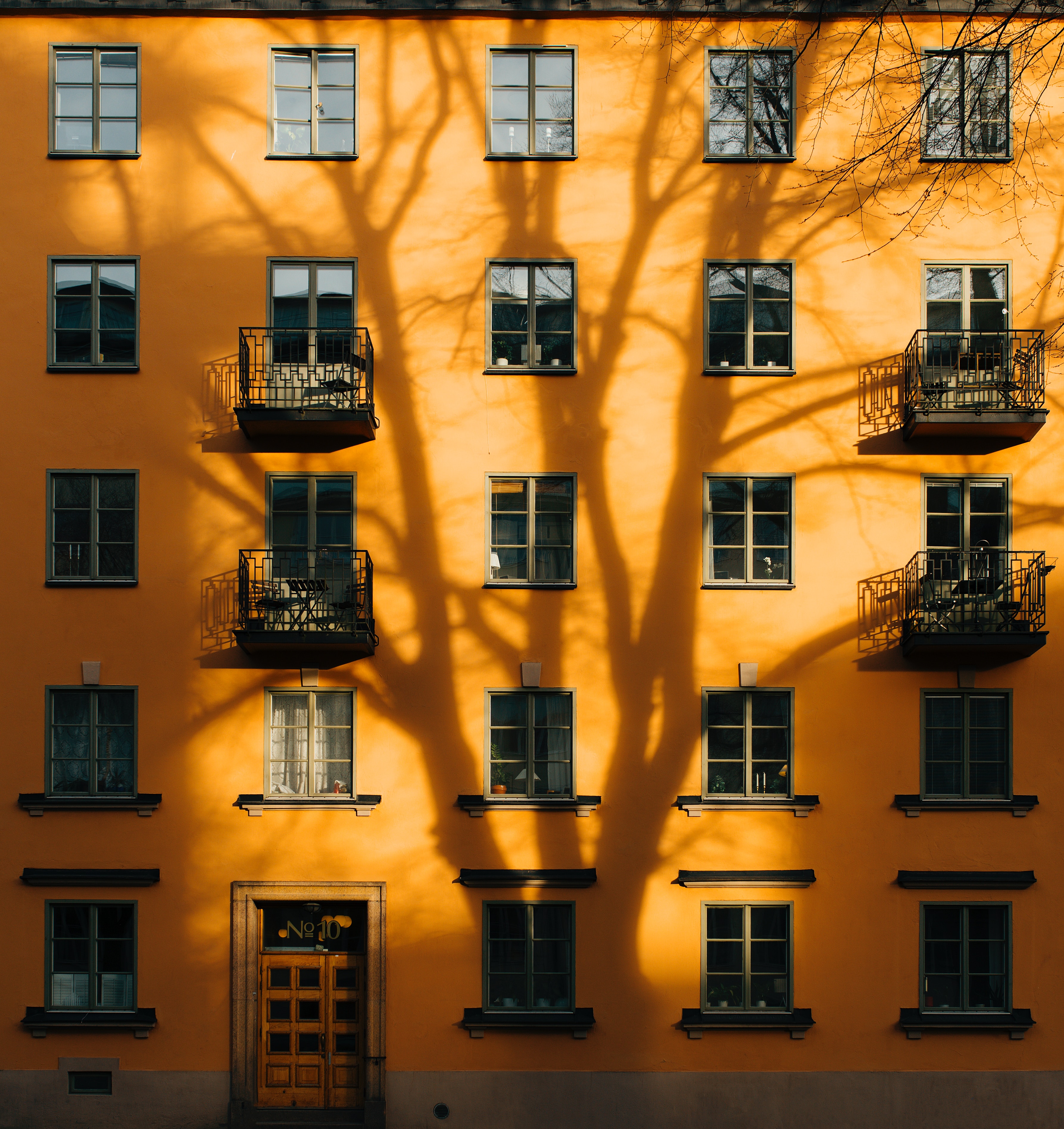 orange building with tree shadow