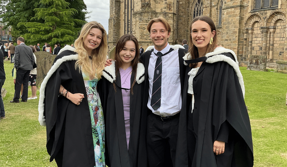 Four graduates outside Durham Cathedral
