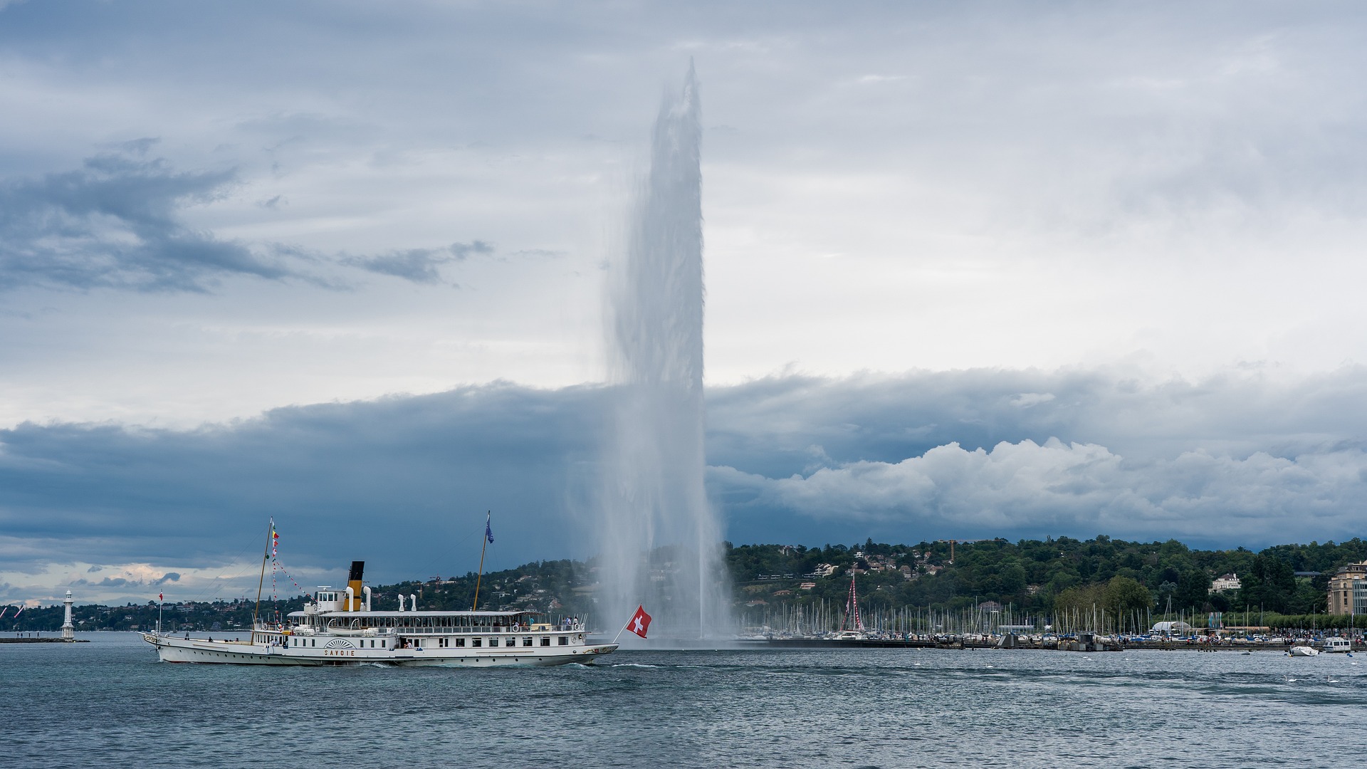 Lake Geneva with a boat and the national flag of Switzerland
