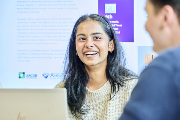 Student sitting behind laptop smiling
