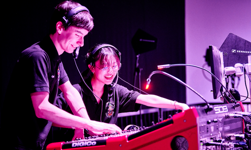 Two students working on a sound mixing desk