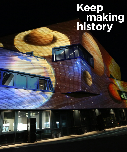 Ogden Centre for Fundamental Physics building at night with images of planets projected onto the outside