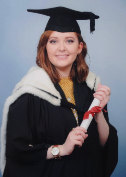 Alice Oseman in graduation gown and mortar board, holding a scroll