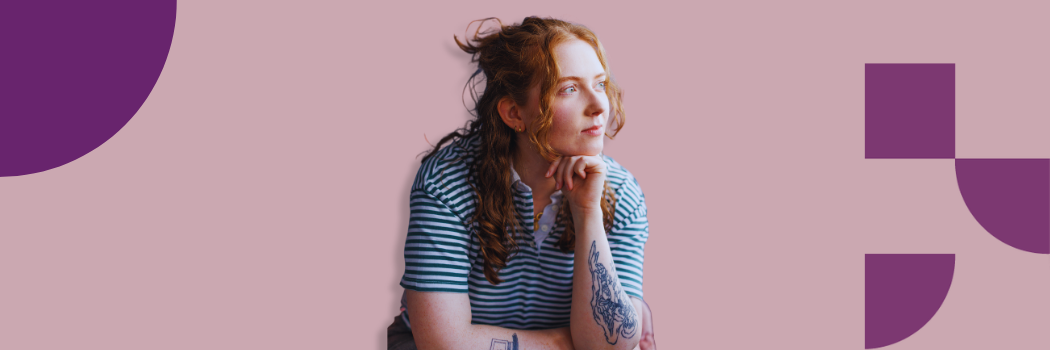 Alice Oseman in striped top, with long red hair, looking to her left