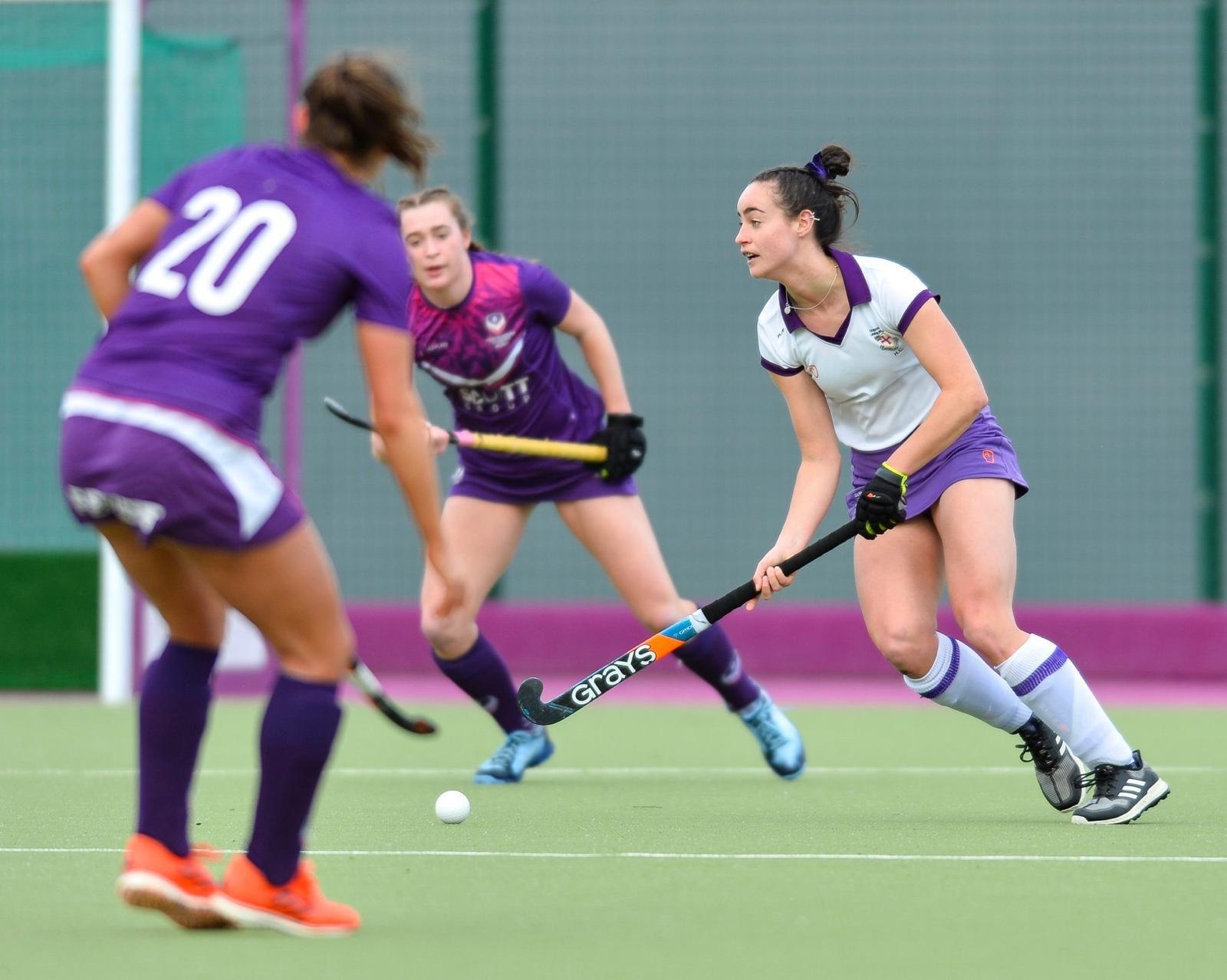 A female hockey player wearing Durham University Hockey Club kit playing in a match