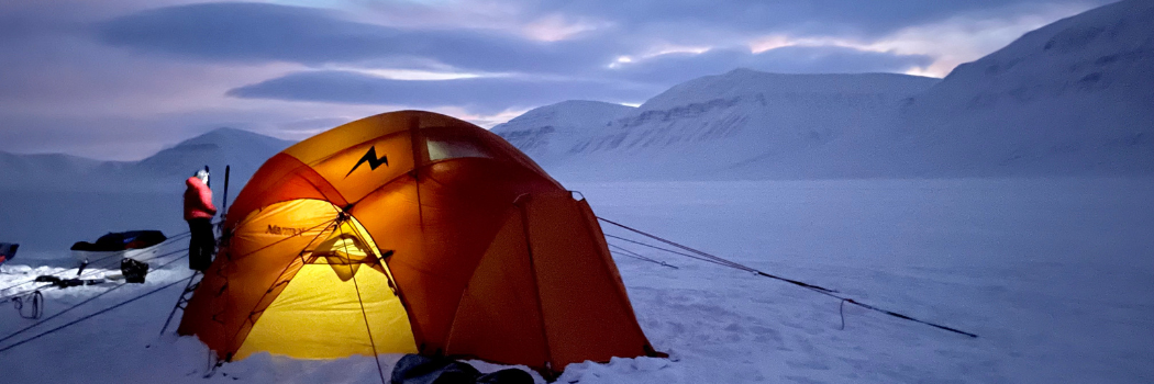 Tent in polar environment with snowy mountains in the background