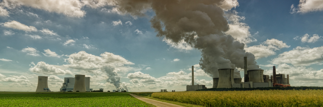 Fossil fuel power stations showing smoke coming out of the chimneys.