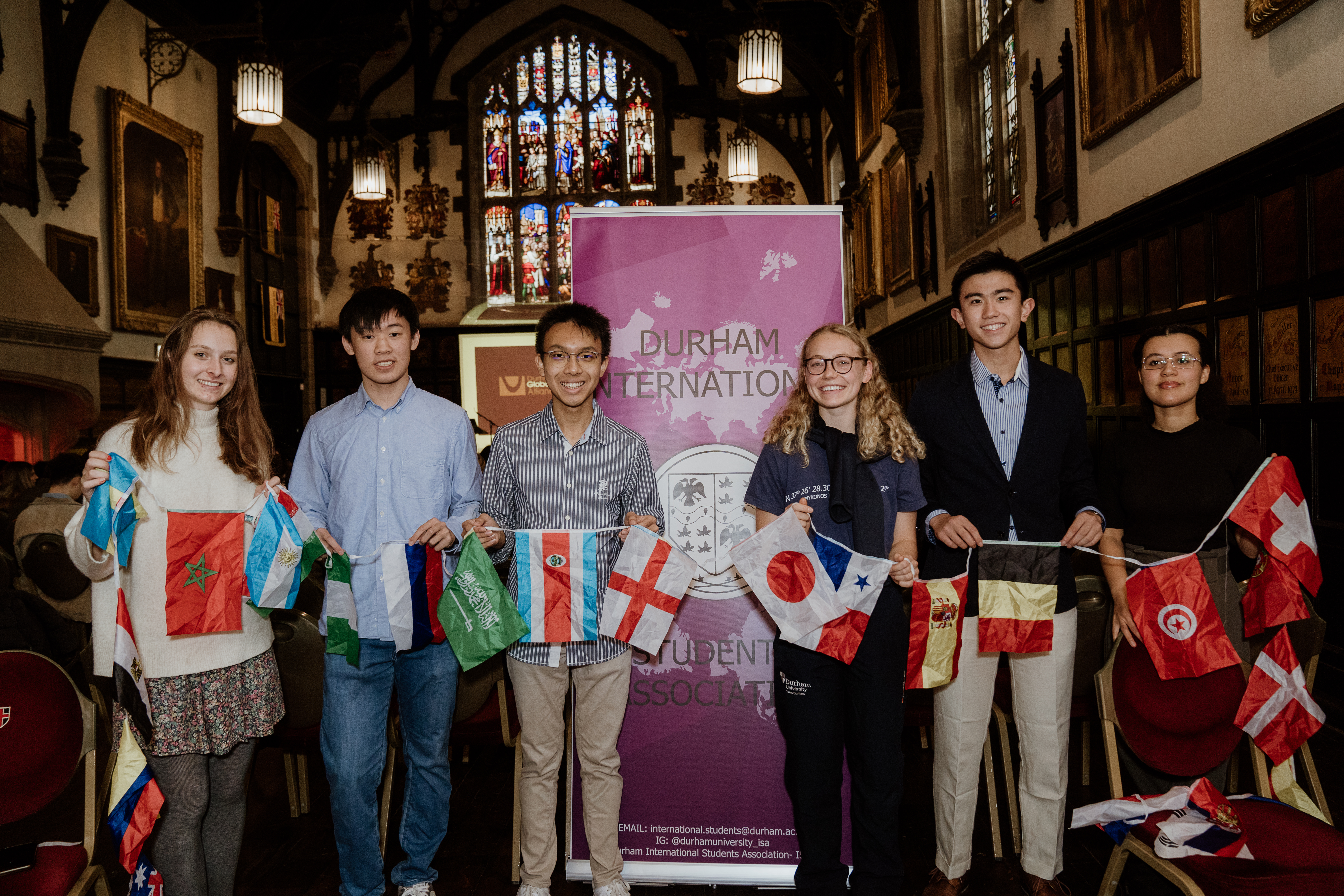 A group of international students holding flags at a civic reception event