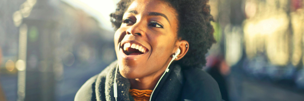 A girl with headphones in singing along to her music.