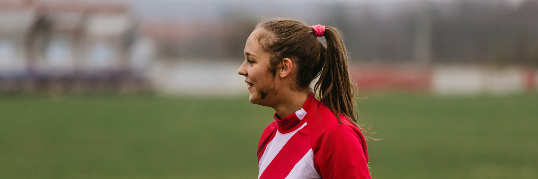 Female football player with mud on her face
