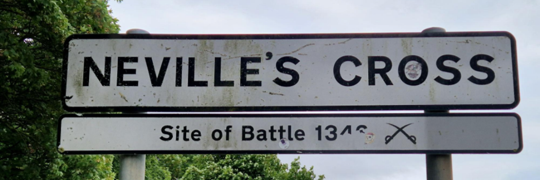 A white road sign stating Neville's Cross.