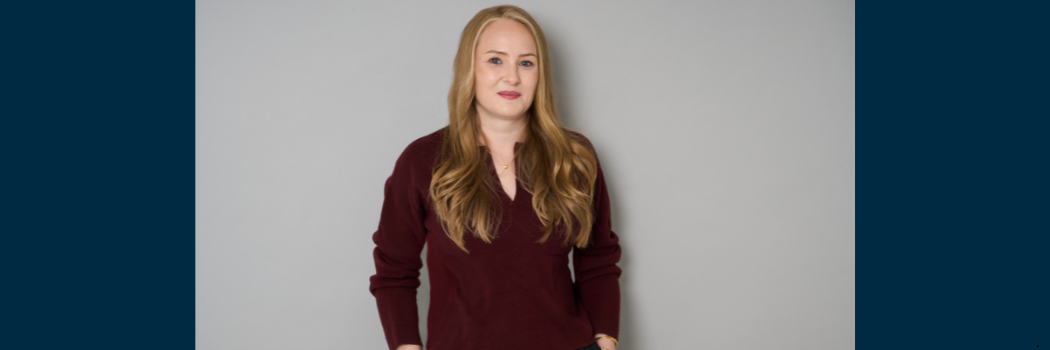 Professor Pippa Petts photographed against a grey background, looking straight to camera