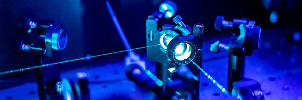 A laser beam being directed through mirrors in a laboratory
