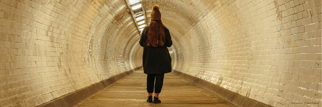 Woman walking alone through a pedestrian tunnel
