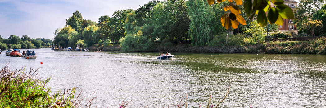 Small boats going along the River Thames in the UK.