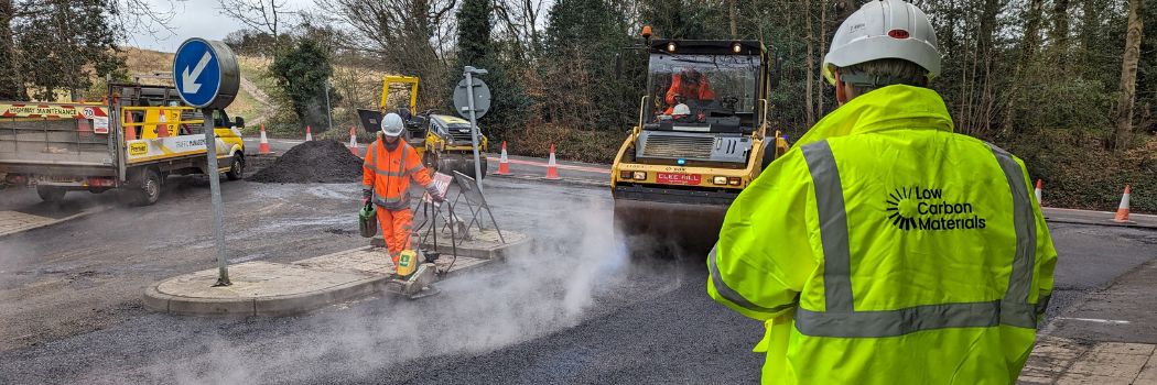 Staff in high-visibility jackets laying asphalt on a road