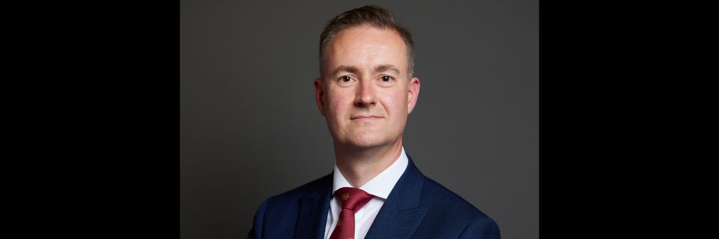 Male wearing suit and tie, looking at camera. Head and shoulders shot