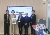 A group of people standing in front of a Sungkyunkwan University sign