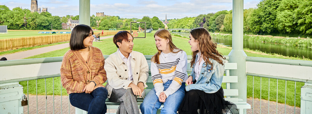 A group of students chatting on a bench
