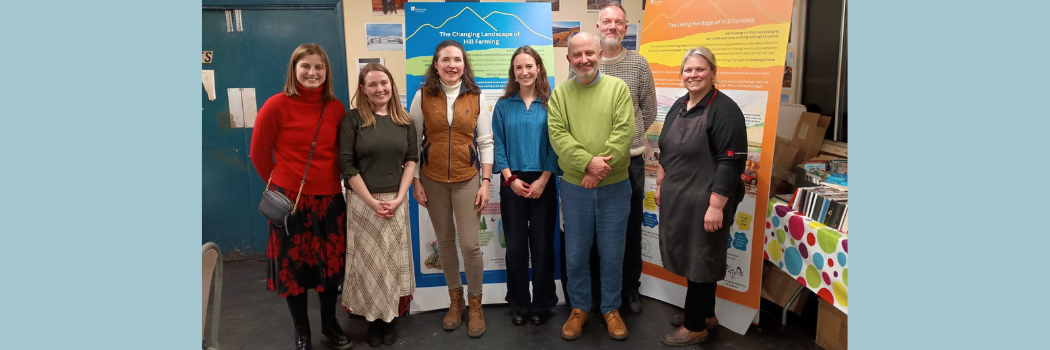 A group of men and women in front of banners smiling