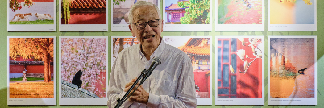 Dr Huang, elderly Chinese gentleman standing in front of exhibition
