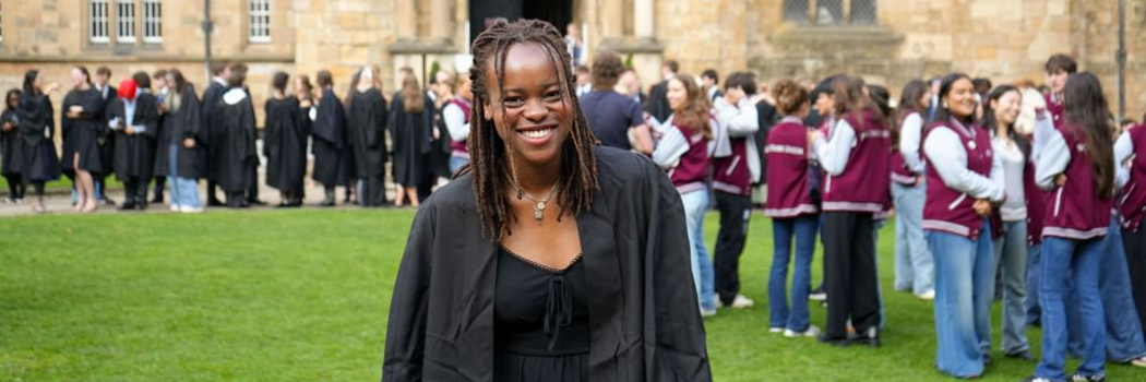Student smiling and standing in front of other students celebrating matriculation next to Durham Castle