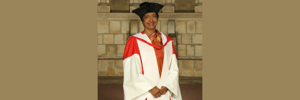 A woman wearing a red and white academic robe and a black academic cap