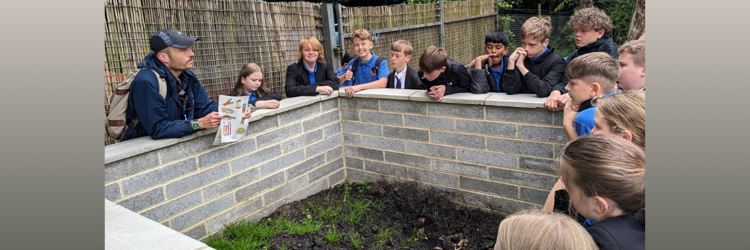School pupils lean on a wall smiling