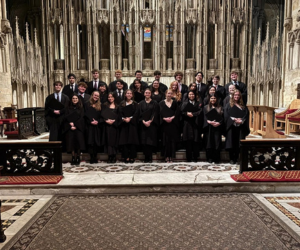 Two rows of students in gowns performing in Cathedral for Grey choir