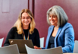 Sonia Virdee with student, looking at a laptop