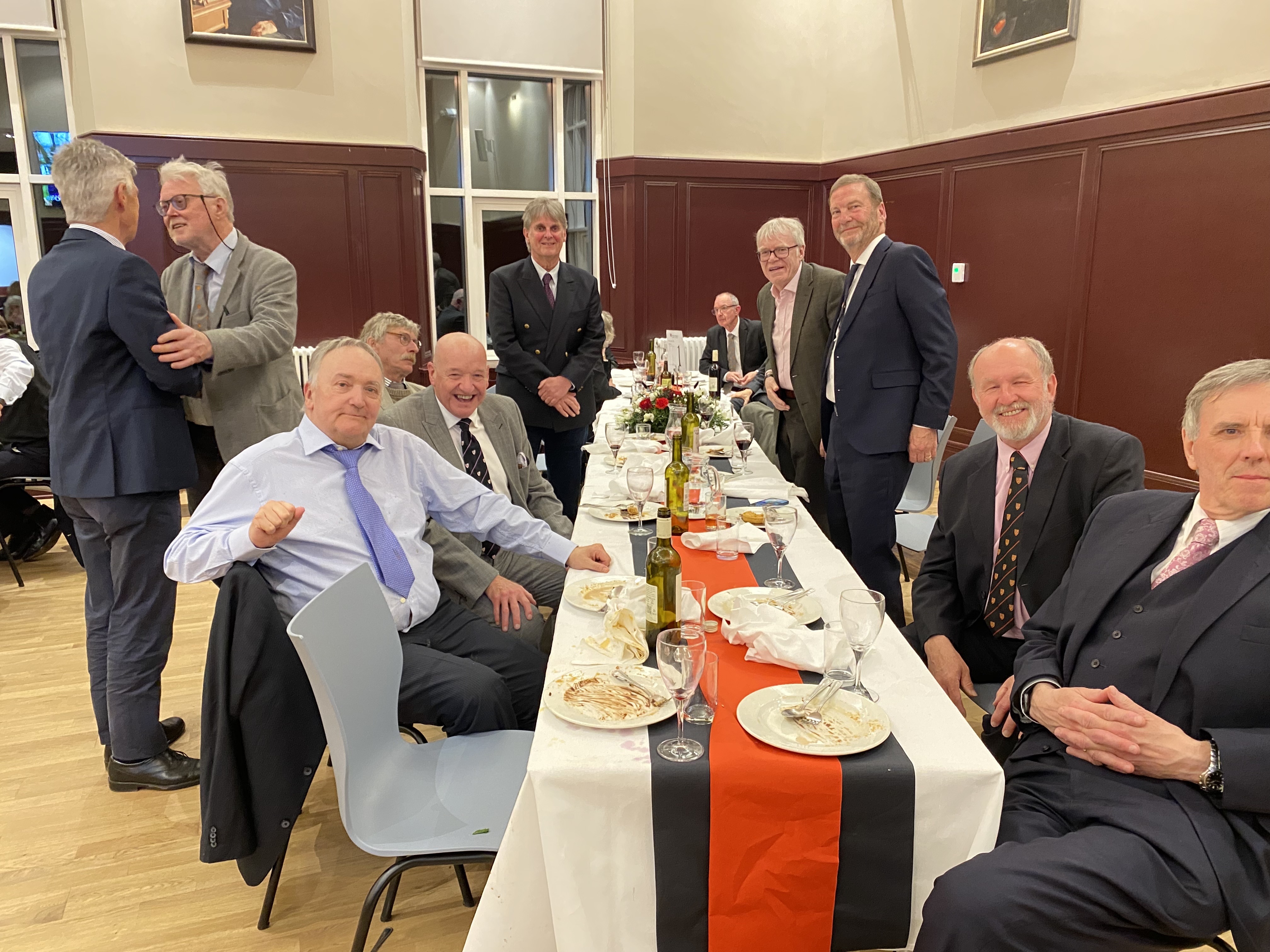 people gathering around a long dining table