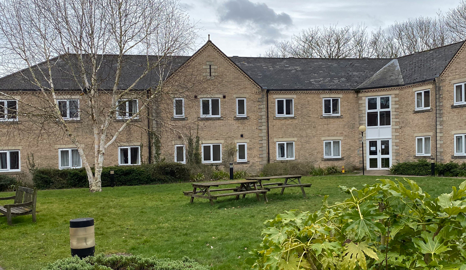 Fonteyn Court (student accommodation at Parson’s Field site), semicircle shaped building with a green lawn and plants in the foreground.