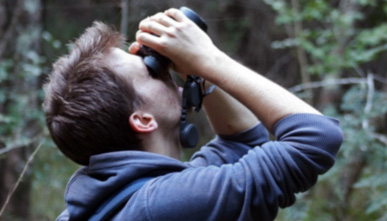 a student looking up through binoculars