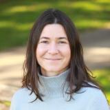 Danielle Johnson smiling at the camera, with a sunlit park in the background