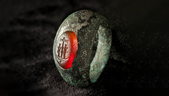 A roman metal ring with an amber stone inset with a design