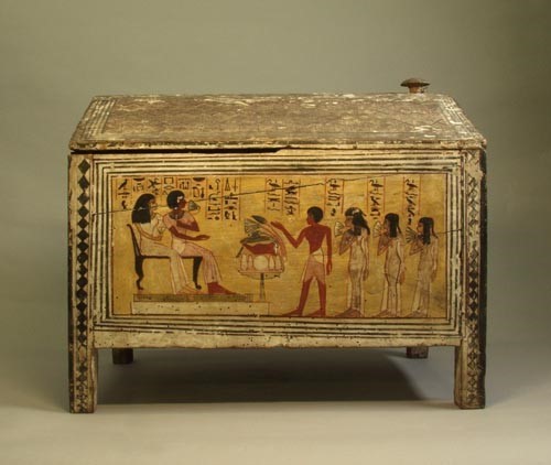 An Egyptian wooden storage box with hieroglyphs and figures depicted in relief