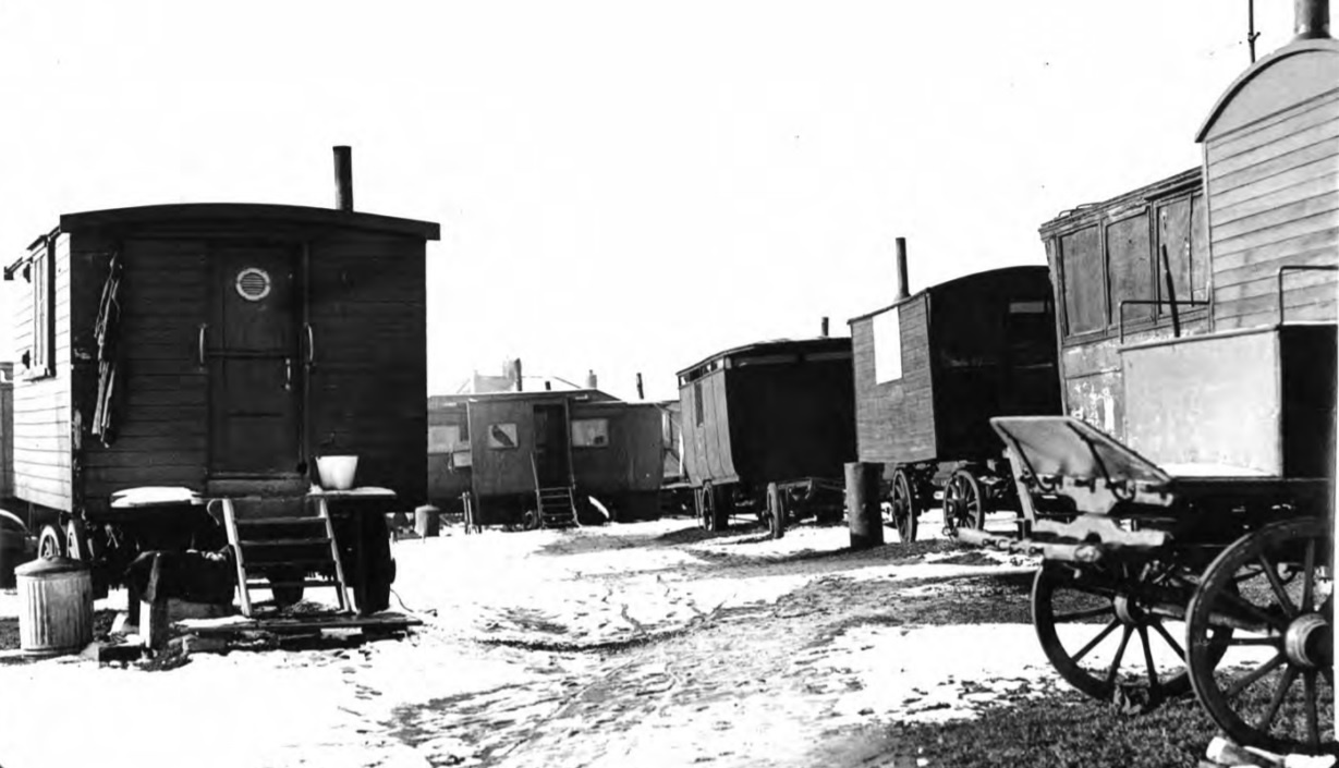A black and white photograph of a number of parked waggons