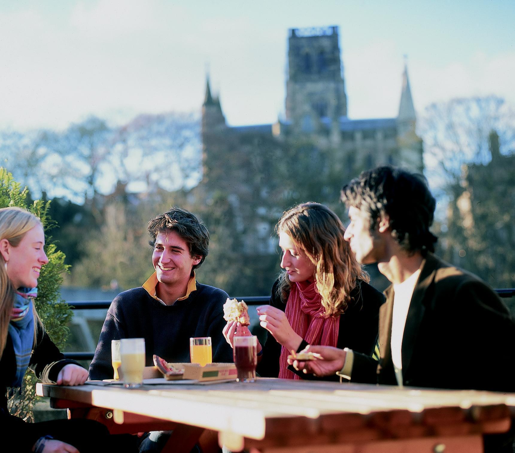 Students sitting with Durham Cathedral in the background