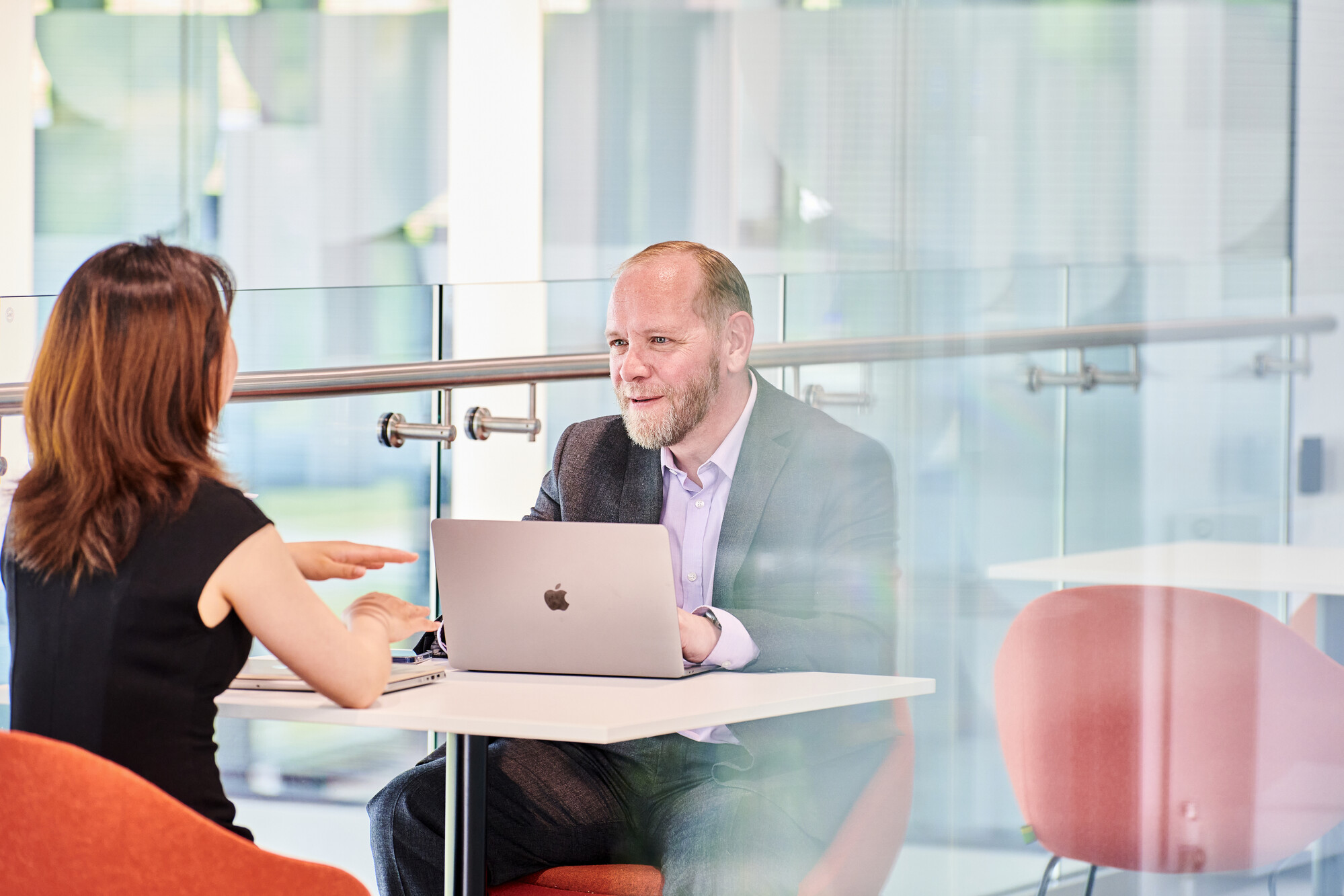 Two people sit at a table talking