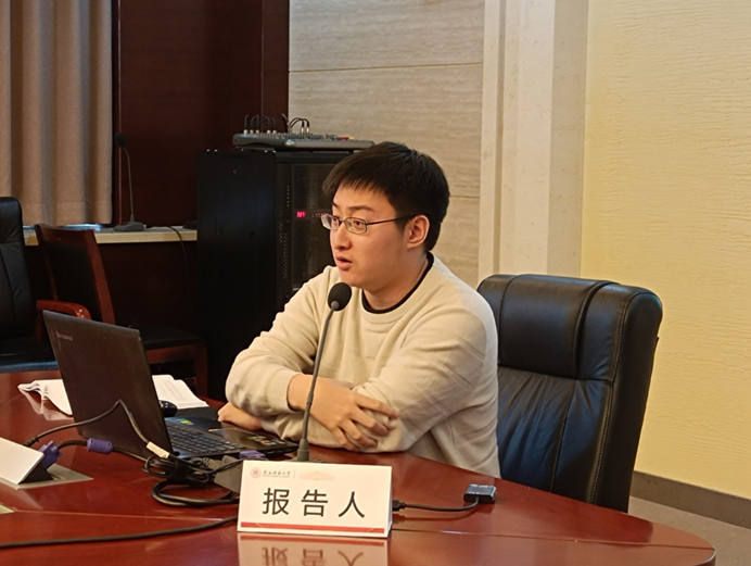 A man sat at a table speaking into a microphone