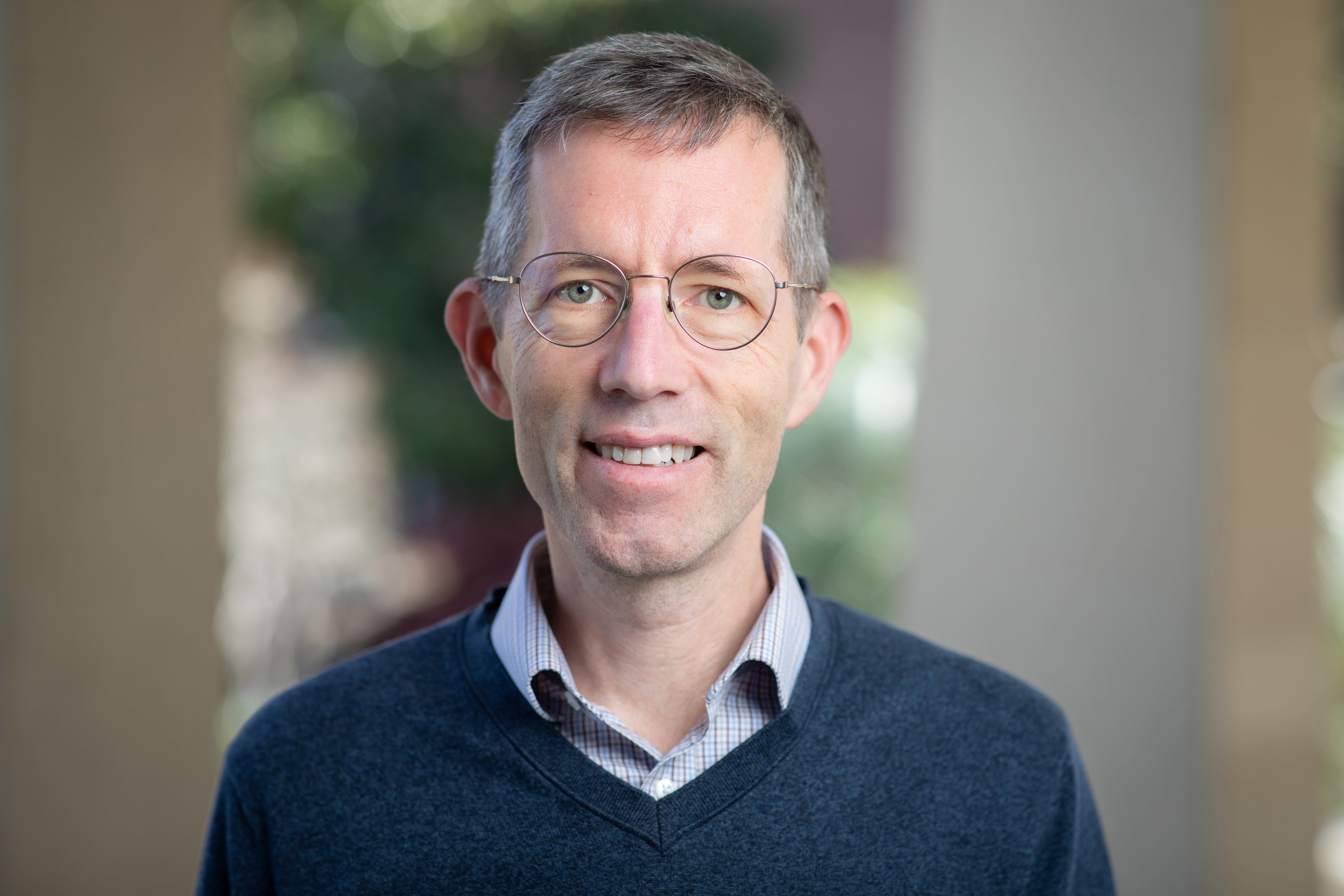 A man with short hair and glasses
